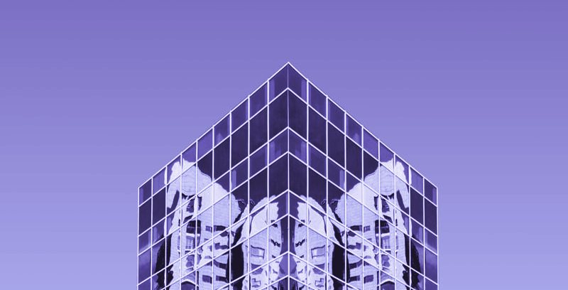 The glass crown of a tower against a violet sky